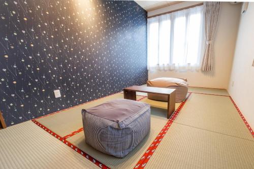 Habitación con 1 dormitorio con una pared con estampado de estrella. en HOPETREE HAKUBA, en Iida