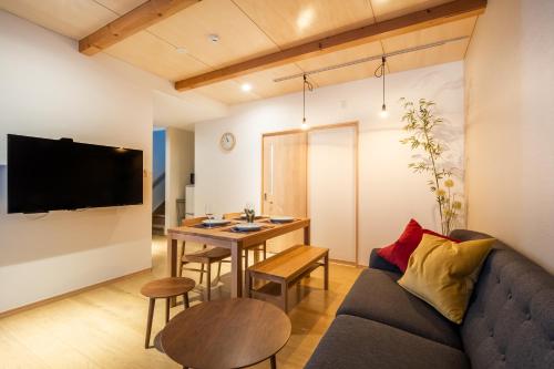 a living room with a couch and a table at HOPETREE HAKUBA in Iida