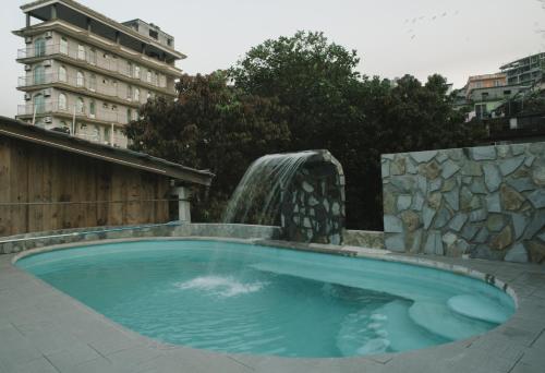 a swimming pool with a water fountain at Hotel Posada San Agustin in Xilitla
