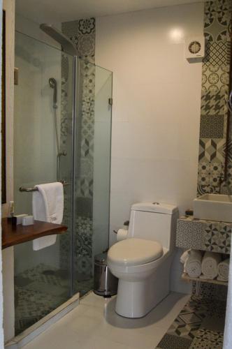 a bathroom with a toilet and a glass shower at Hotel de Piedra in Bernal