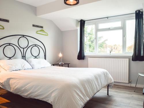 a bedroom with a large white bed and a window at Sidelands Sojourn in Stratford-upon-Avon