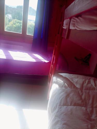 1 dormitorio con litera y ventana en Hospedaje de Ensueño SMA en San Martín de los Andes
