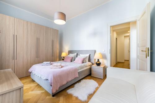a bedroom with a large bed with pink pillows at Big bright two-bedroom apartment in Prague Old Town in Prague