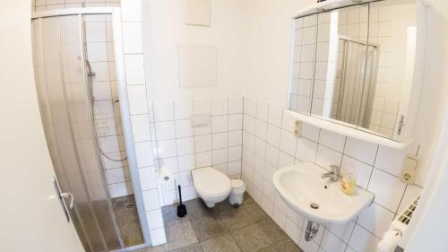 a white bathroom with a sink and a toilet at Appartementhaus Greta im Ostseebad in Ostseebad Sellin