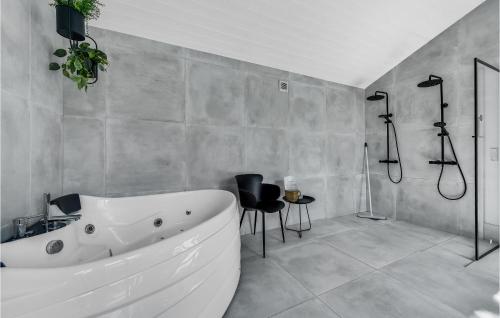 ein Badezimmer mit einer großen weißen Badewanne und einer Dusche in der Unterkunft Stunning Home In Blvand With Kitchen in Blåvand
