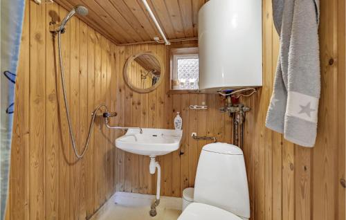 a wooden bathroom with a toilet and a sink at Amazing Home In Esbjerg V With House Sea View in Esbjerg