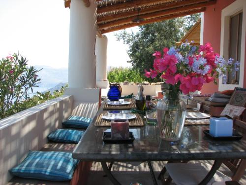 una mesa con flores en un jarrón en un balcón en Casa Rossa del Cappero Sottano en Lipari