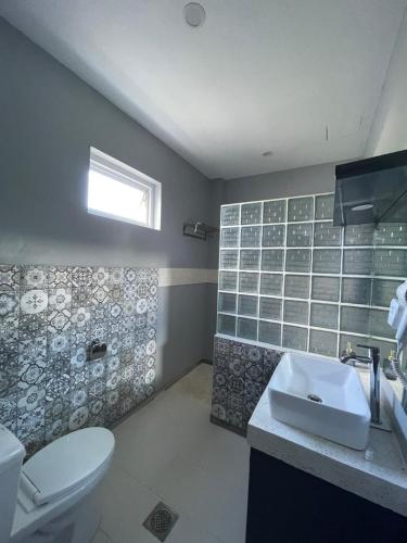 a bathroom with a white toilet and a sink at Bella Napoli Resort & Resto in Panglao Island