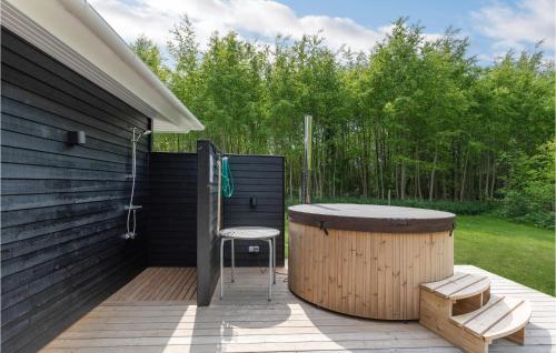 a wooden deck with a hot tub and a chair at Holiday Home Toftegårdsvej Hasle X in Tofte