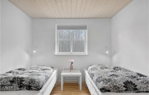 2 camas en una habitación con mesa y ventana en 3 Bedroom Nice Home In Hasle en Tofte