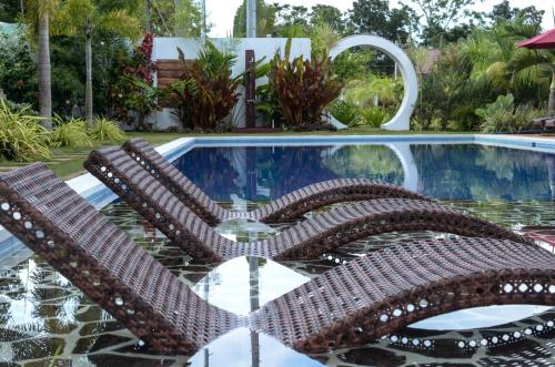 a pair of chairs sitting in front of a pool at Bella Napoli Resort & Resto in Panglao
