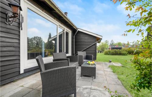 a patio with wicker chairs and a table at 3 Bedroom Lovely Home In Kalundborg in Kalundborg