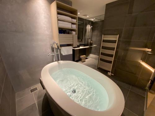 een badkamer met een bad en een wastafel bij Condominium ISHITEI Furano in Furano