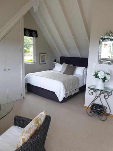 a bedroom with two beds and a table and a chair at Brenton Lodge in Whangamata