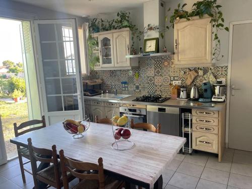 une cuisine avec une table en bois avec des chaises et une tableasteryasteryasteryasteryasteryastery dans l'établissement Maison de vacances à bergerac, à Bergerac