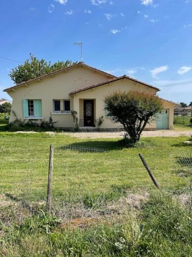une maison dans un champ avec une clôture devant elle dans l'établissement Maison de vacances à bergerac, à Bergerac