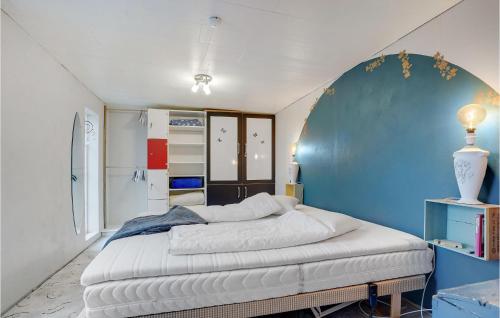 1 dormitorio con 1 cama con pared azul en Pet Friendly Home In Roslev With Wifi en Roslev