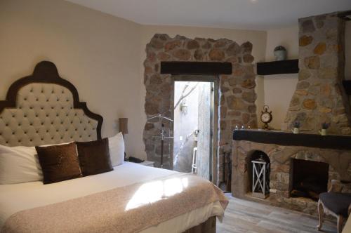 a bedroom with a large bed and a fireplace at Hotel de Piedra in Bernal