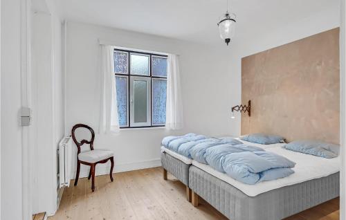 ein Schlafzimmer mit einem Bett, einem Stuhl und einem Fenster in der Unterkunft 1 Bedroom Cozy Apartment In Svendborg in Svendborg