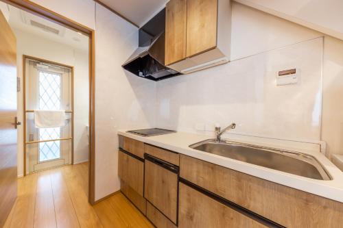 a kitchen with a sink and a window at HOPETREE CoCo HAPPO TOWNS in Hakuba