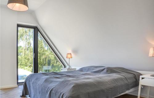 a white bedroom with a bed and a large window at 4 Bedroom Lovely Home In Dragr in Dragør