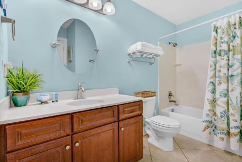 a bathroom with a sink and a toilet and a mirror at Ocean Villa Penthouse #2302 in Panama City Beach