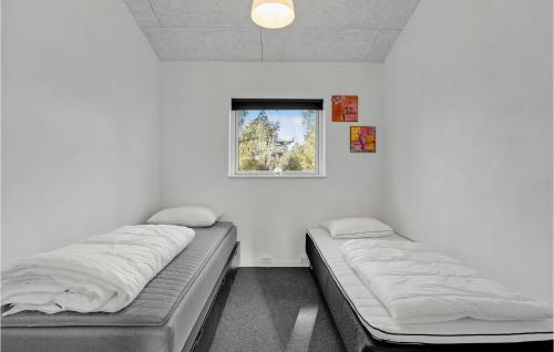 two beds in a room with a window at 4 Bedroom Beautiful Home In Rødby in Rødby