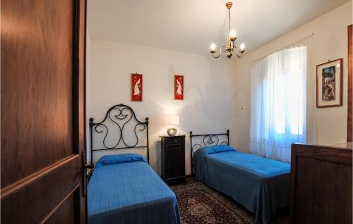 um quarto com 2 camas e um lustre em Nice Home In Colle Di Buggiano With Kitchen em Colle di Buggiano