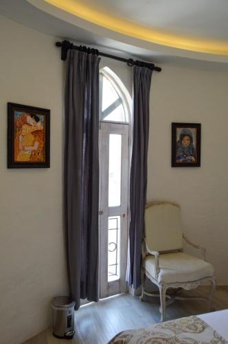 a bedroom with a window with a chair at Hotel de Piedra in Bernal