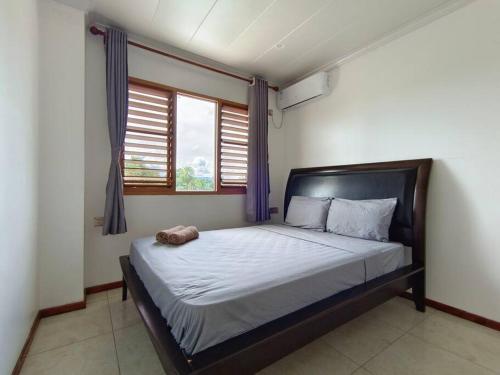 1 dormitorio con 1 cama grande y cortinas azules en 2 bedroom Apartment, en Nadi