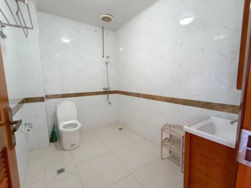 a white bathroom with a toilet and a sink at 2 bedroom Apartment in Nadi