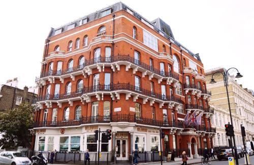 un gran edificio de ladrillo rojo en la esquina de una calle en The Harrington - Gloucester Road - 1 Harrington Gardens, en Londres