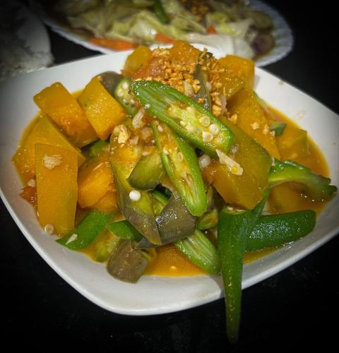a plate of food with vegetables on a table at Playa Alegre Beach Resort & Restaurant in Tanauan