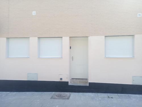 a white building with four windows and a door at MINI ESTUDIOS SANSE in San Sebastián de los Reyes