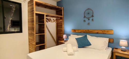 a bedroom with a white bed and a blue wall at Calao Villa, Solar Villa 2 rooms with Private Pool in El Nido