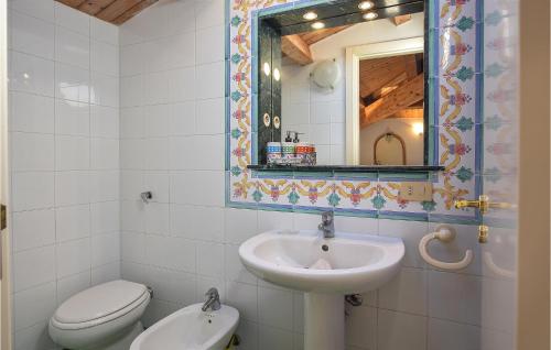 ein Badezimmer mit einem Waschbecken, einem WC und einem Spiegel in der Unterkunft Cozy Home In Sampieri With House A Panoramic View in Sampieri