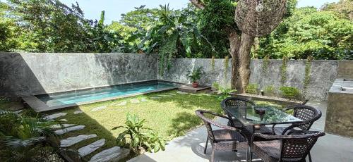 a backyard with a pool and a table and chairs at Calao Villa, Solar Villa 2 rooms with Private Pool in El Nido