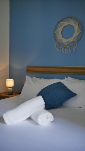 a bed with white sheets and a blue pillow at Calao Villa, Solar Villa 2 rooms with Private Pool in El Nido