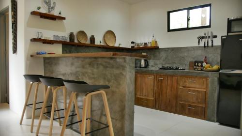 a kitchen with wooden cabinets and bar stools at Calao Villa, Solar Villa 2 rooms with Private Pool in El Nido
