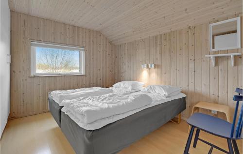 Bøtø Byにある4 Bedroom Lovely Home In Idestrupのベッドルーム(大型ベッド1台、青い椅子付)