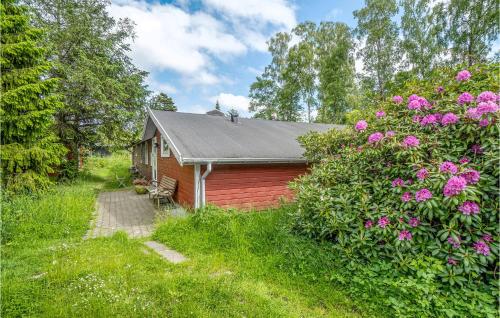a small red house in a field with pink flowers at Holiday Home Rorvig With Hot Tub Iii in Rørvig