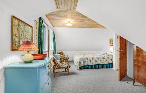 una camera con un letto e un comò con una lampada sopra di Beautiful Home In ster Ulslev With Kitchen a Øster Ulslev