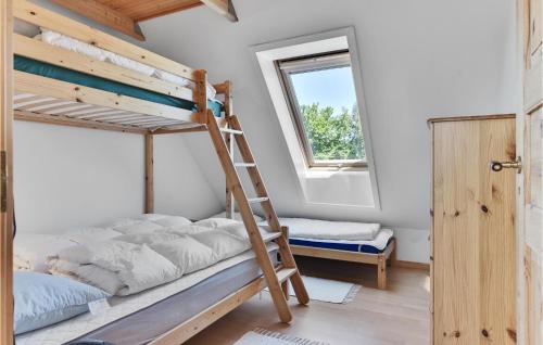 a bedroom with two bunk beds and a window at Fuglsang in Tranekær