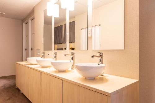 een rij van drie wastafels in een badkamer bij Akasaka The Hostel in Tokyo