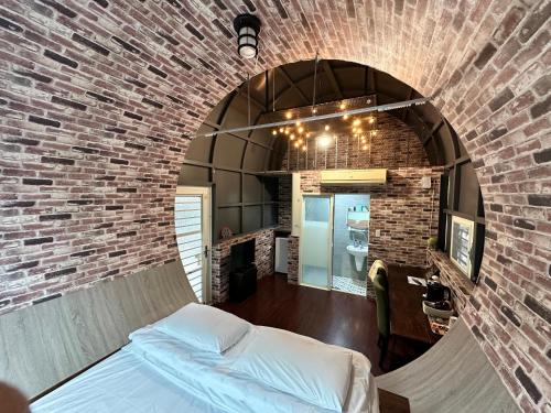 a bedroom with a brick wall with a bed in it at Mei Nong Villa in Meinong