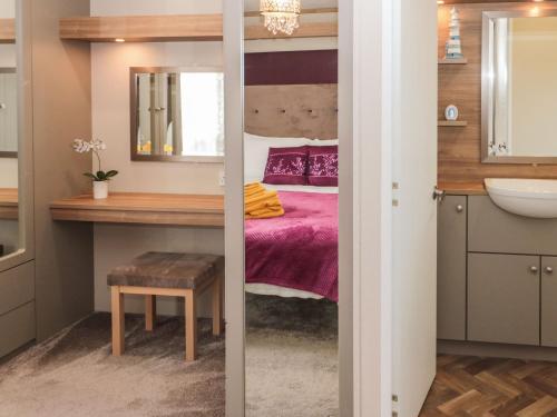 a bedroom with a bed and a sink and a mirror at La Hacendia Lodge in Morpeth