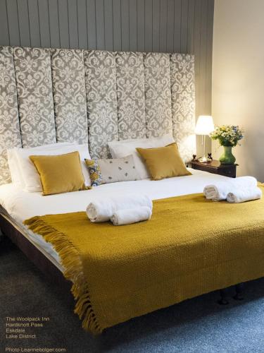 a bedroom with a large bed with towels on it at Woolpack Inn in Eskdale