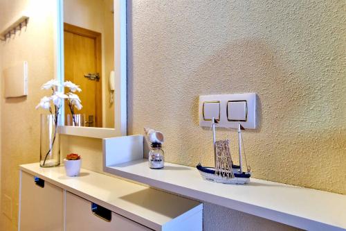 a bathroom counter with a mirror and flowers on it at Espanhouse La Zenia 109 in Orihuela Costa