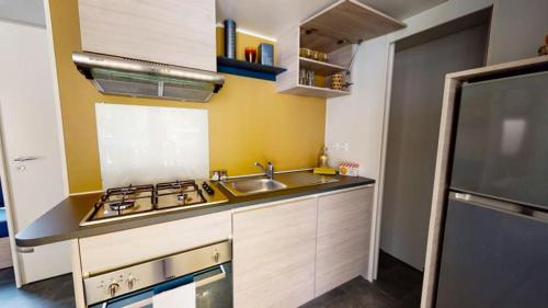 a small kitchen with a sink and a stove at Camping Officiel Siblu Les Embruns in Lège-Cap-Ferret