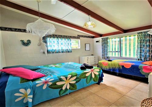 a bedroom with two beds with flowers on them at Ann's Beach House in Rarotonga